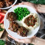 holding a plate of Salisbury steak with mashed potatoes