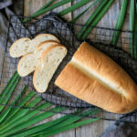 slices of Cuban bread with loaf on a cooling rack