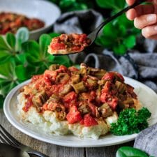 a forkful of skillet Southern okra and tomatoes with greenery