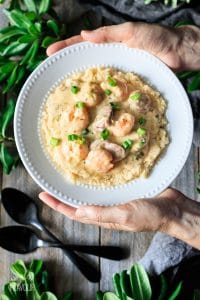 holding a bowl of shrimp and grits
