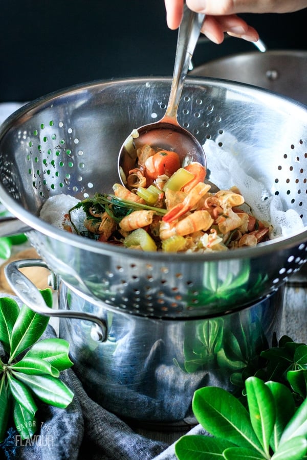 straining out the shells from seafood stock