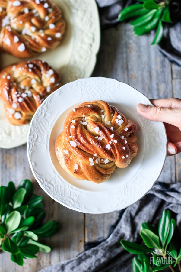 holding a Swedish cardamom bun on a plate