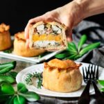 holding a chicken, bacon, and apricot pie cut in half