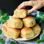 person taking one of the pumpkin dinner rolls
