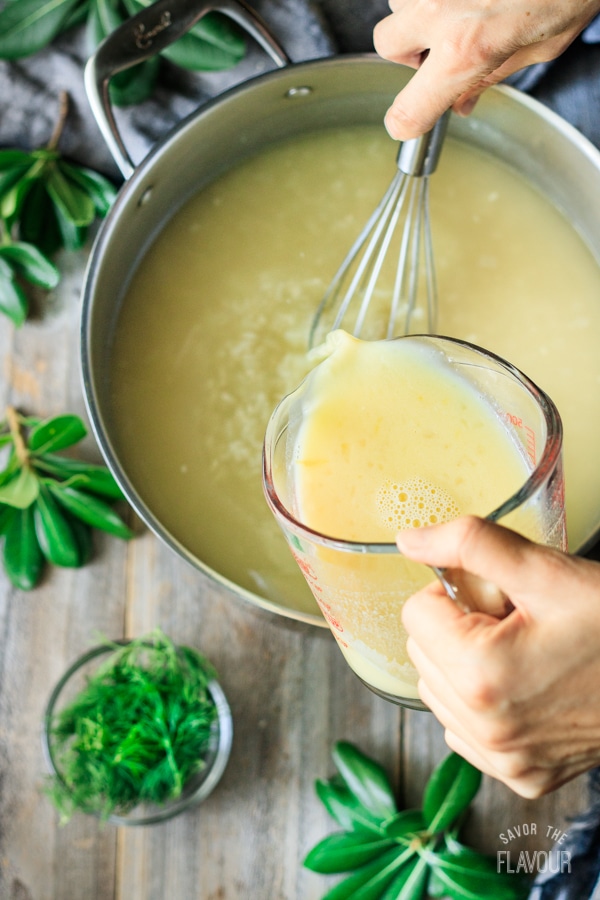 pouring egg and lemon juice mixture into Greek lemon chicken soup