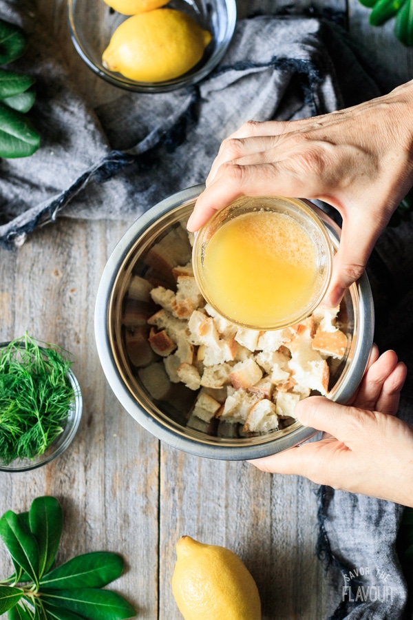pouring melted butter on croutons for Greek lemon chicken soup