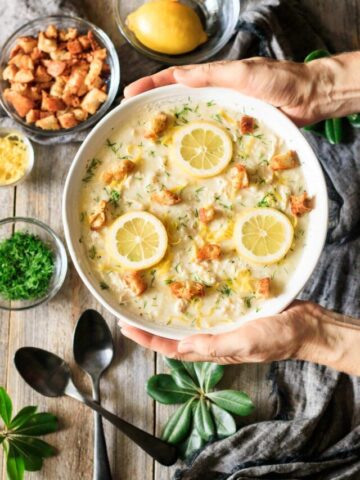holding a bowl of lemon chicken soup.