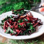 holding a forkful of sautéed beet greens