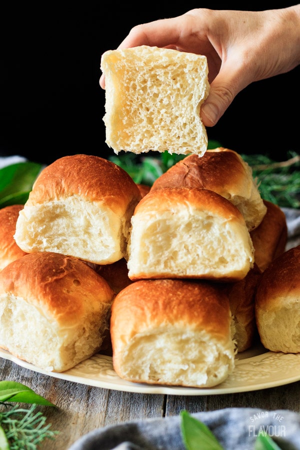 holding one of the Hawaiian sweet rolls cut in half