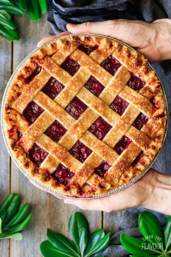 holding a baked cherry pie
