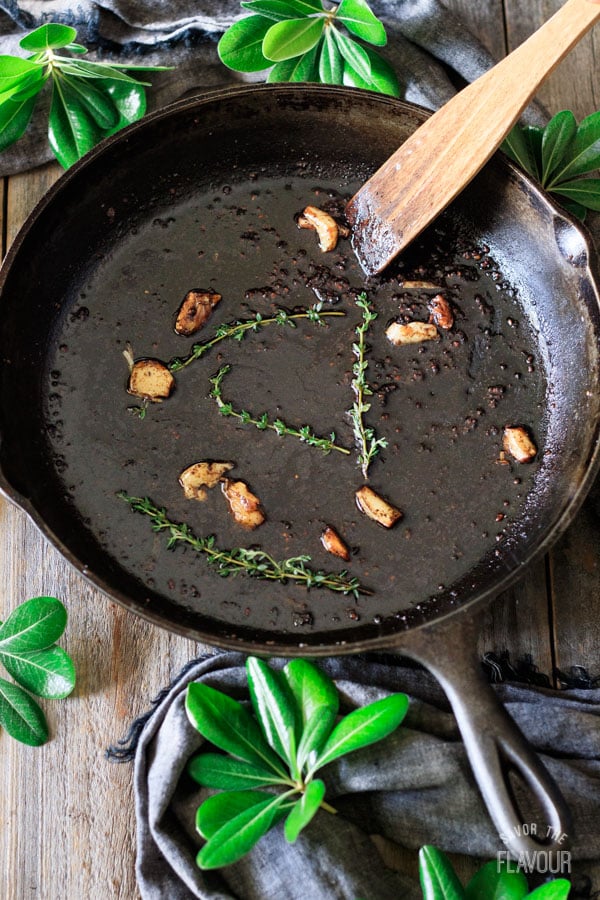 cooking garlic and thyme in a cast iron skillet