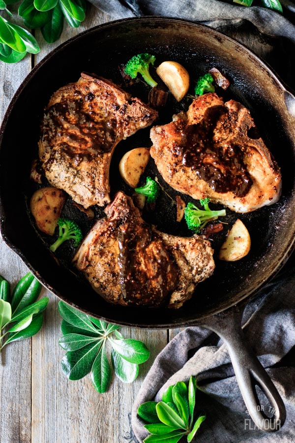 putting pan sauce on pork chops