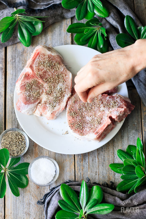 sprinkling spices on pork chops