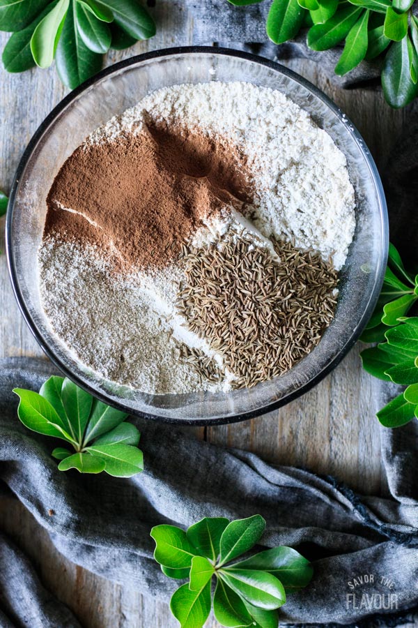 adding cocoa powder and caraway seeds to flour mixture