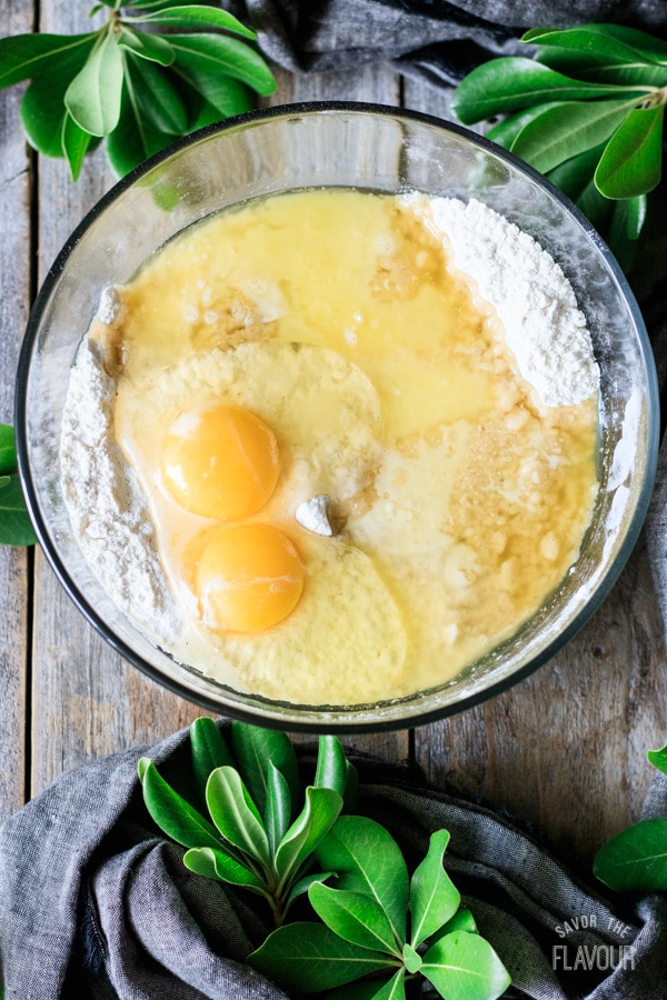 adding eggs and melted butter to flour mixture