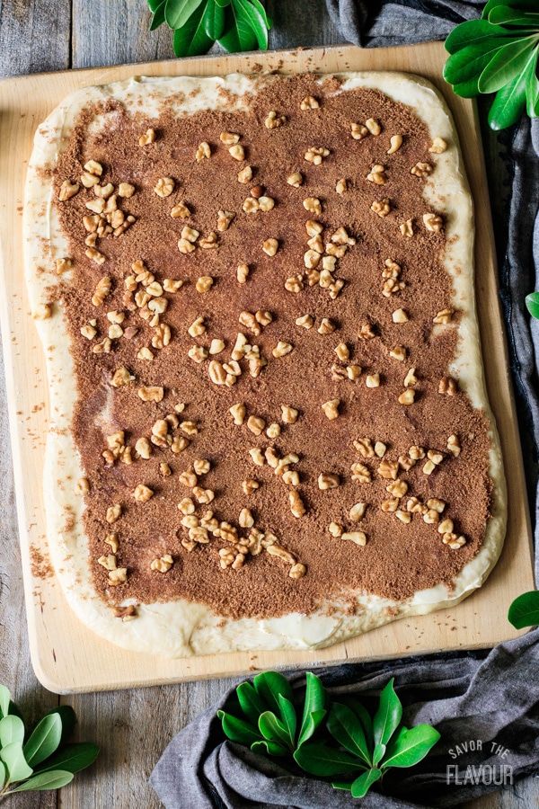 spreading the dough with butter, cinnamon sugar, and walnuts