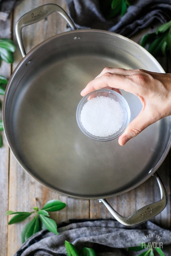 adding salt to pot of boiling water