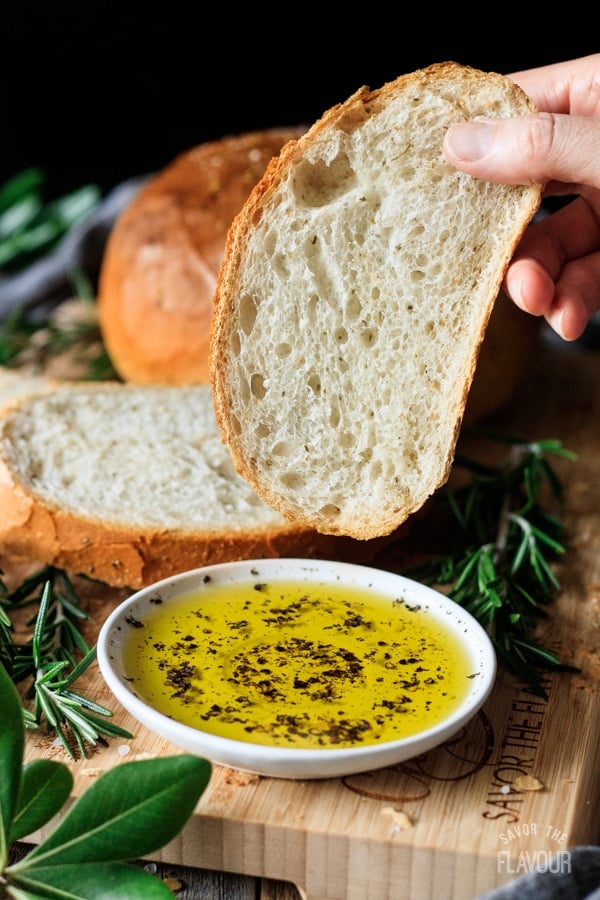 person holding a slice of rosemary bread