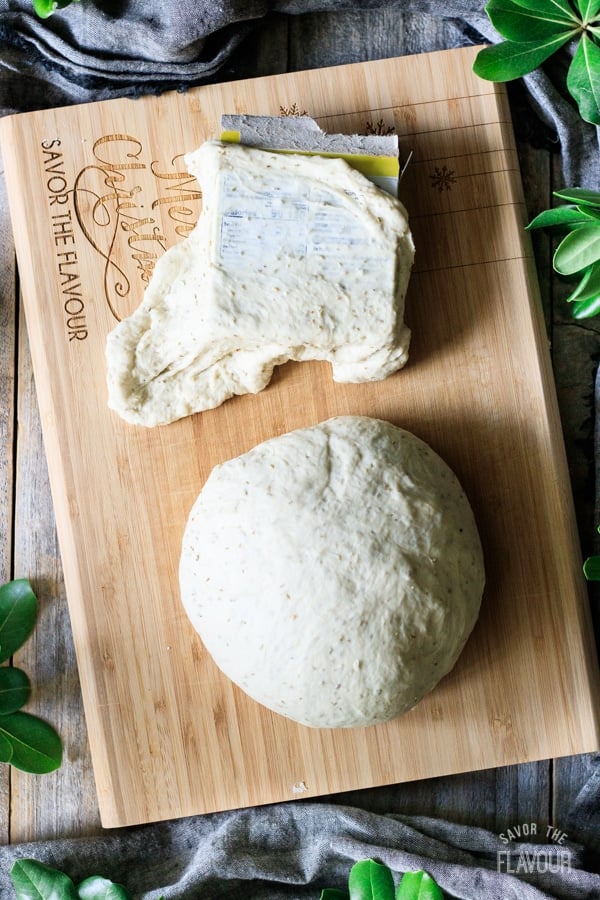 stretching a piece of bread dough over a box
