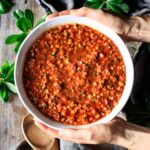 person holding a bowl of hamburger barley soup