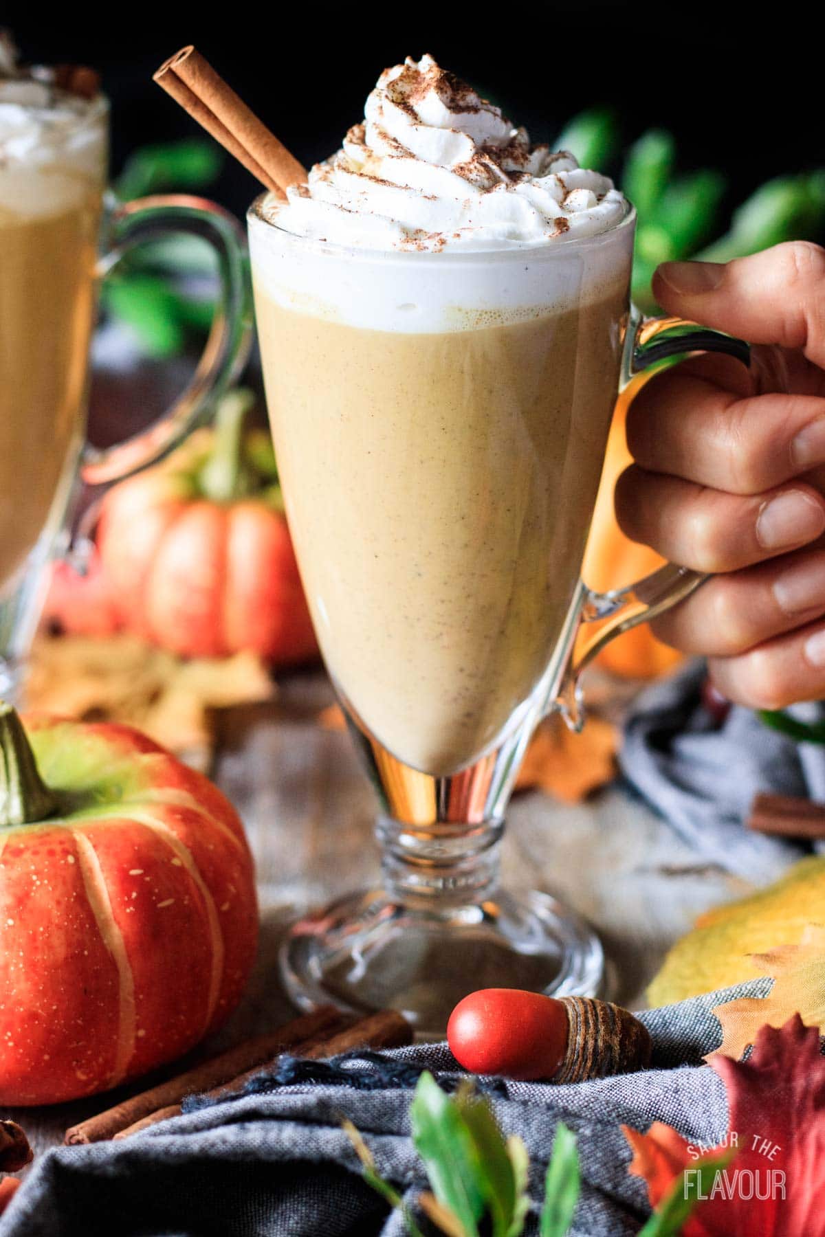 person holding a glass of pumpkin spice latte