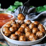 person holding a Hawaiian meatball on a fork