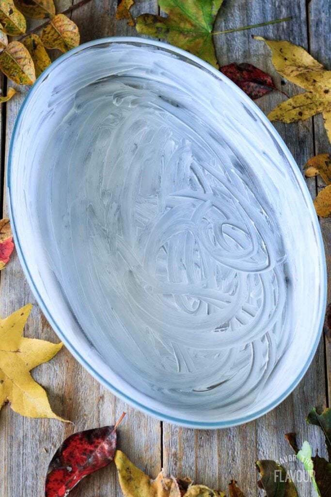 buttered oval glass casserole dish