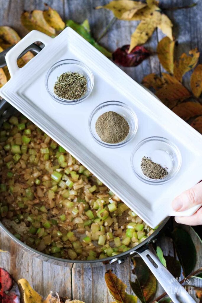 adding spices to pan of cooked veggies