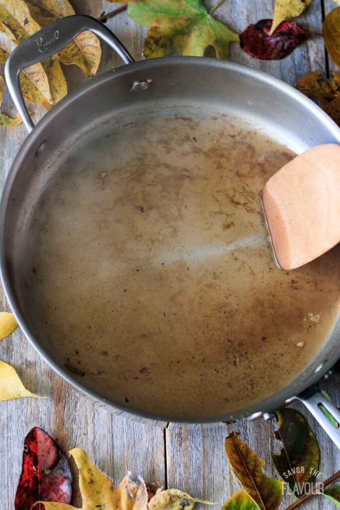 deglazing the skillet with a wooden turner
