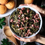 person holding a bowl of collard greens