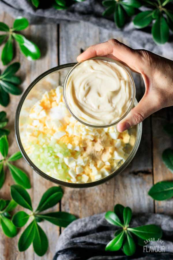 person holding a bowl of mayo