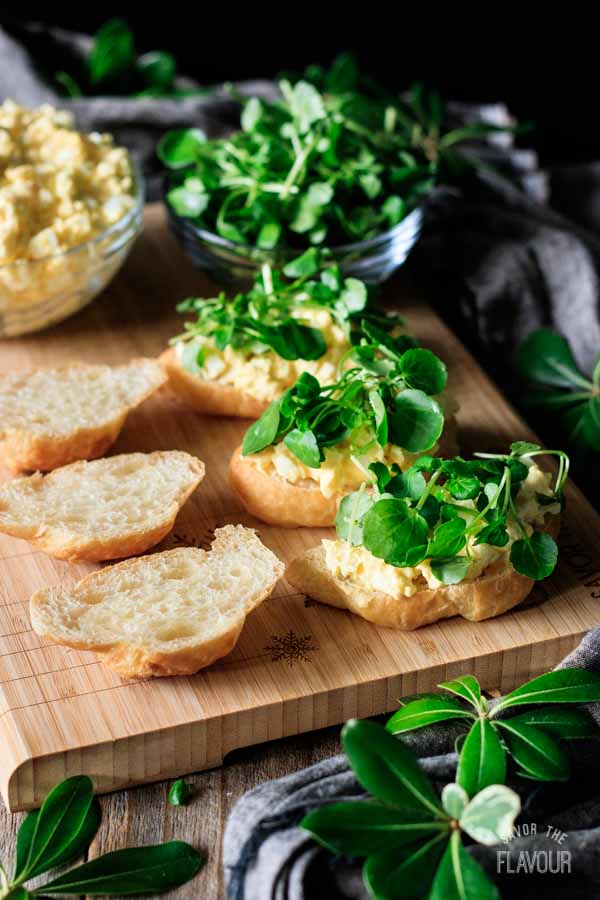 sprinkling watercress on egg salad sandwiches