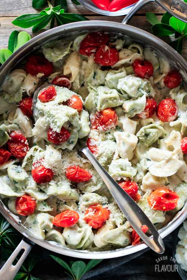 pan of basil alfredo sauce with a spoon