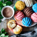 a cup of hot chocolate with a plate of manteconchas