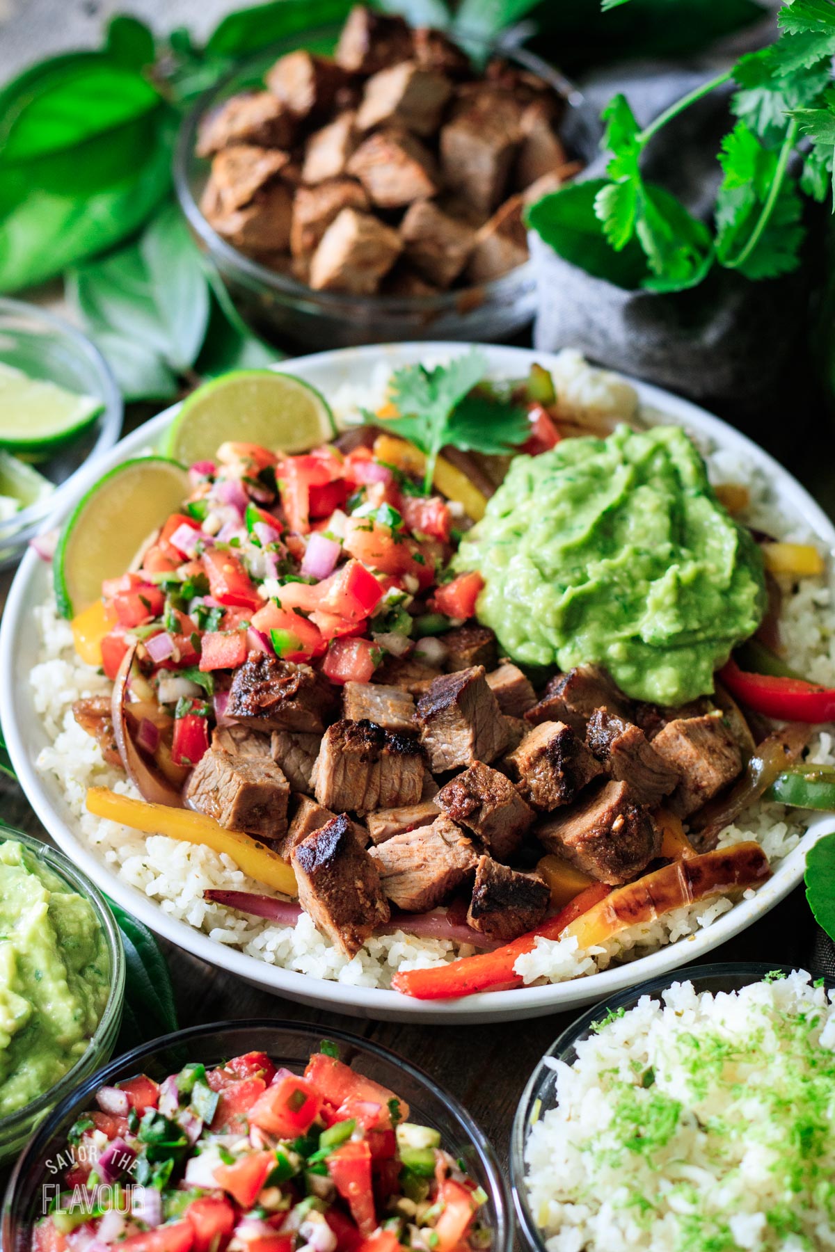 Chipotle steak in a bowl with rice, guac, and pico de gallo