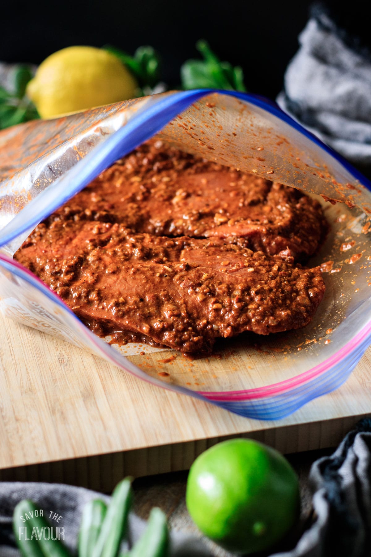 steaks covered with marinade in a ziploc bag