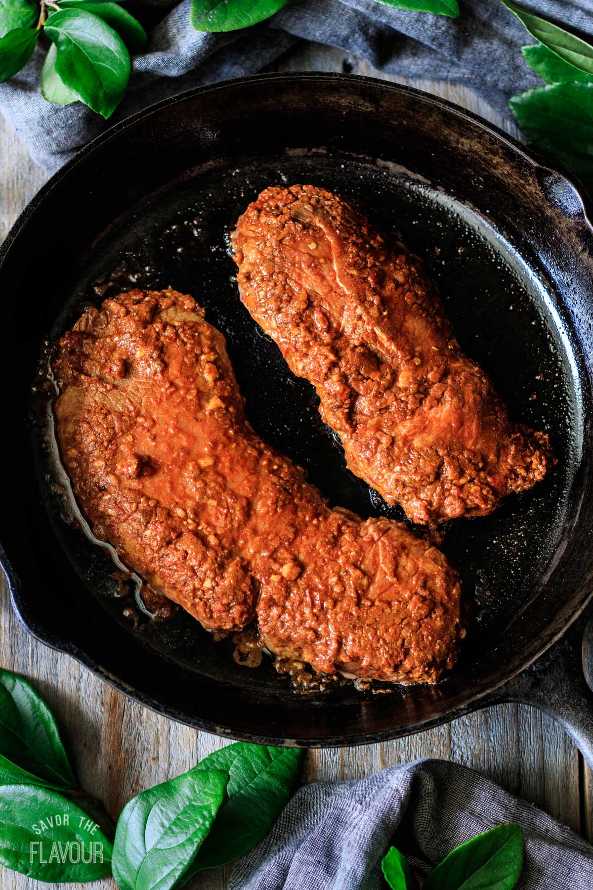 steaks pan frying in a cast iron skillet