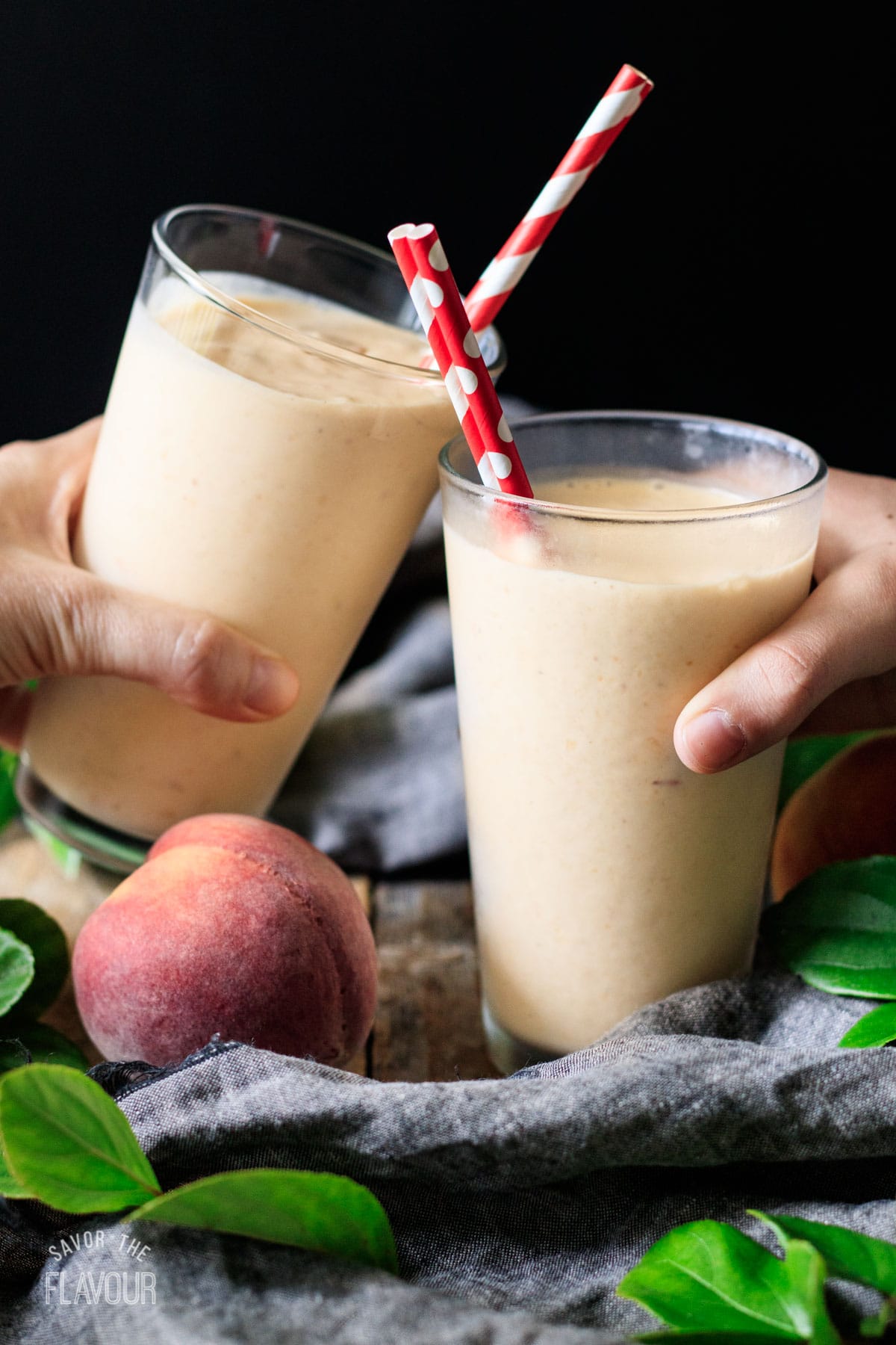 pessoas fazendo um brinde com dois copos de pêssego milkshake