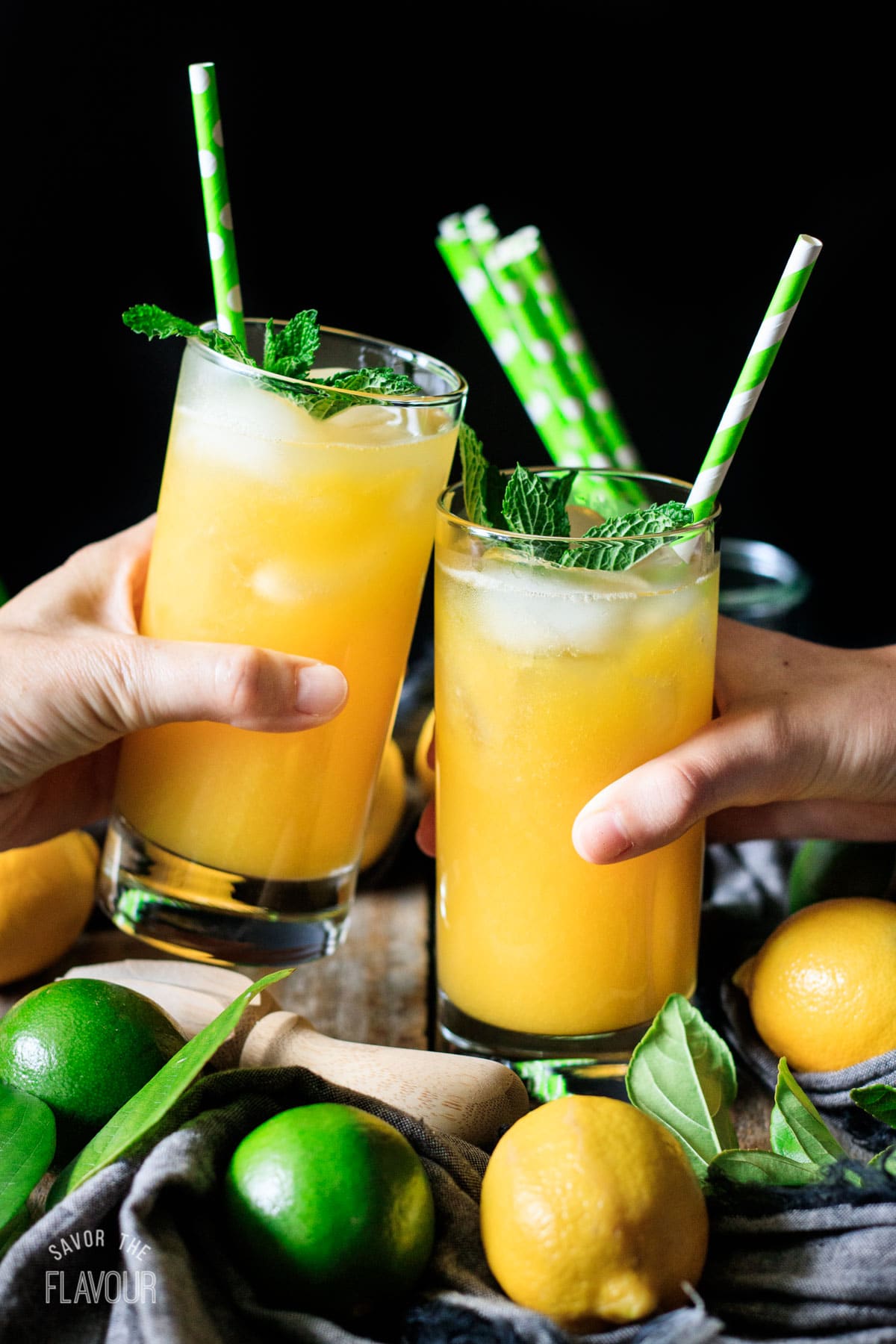 people doing a toast with two glasses of mango lemonade