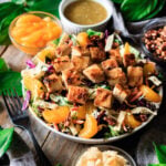 bowl of Asian chicken salad with bowls of topping