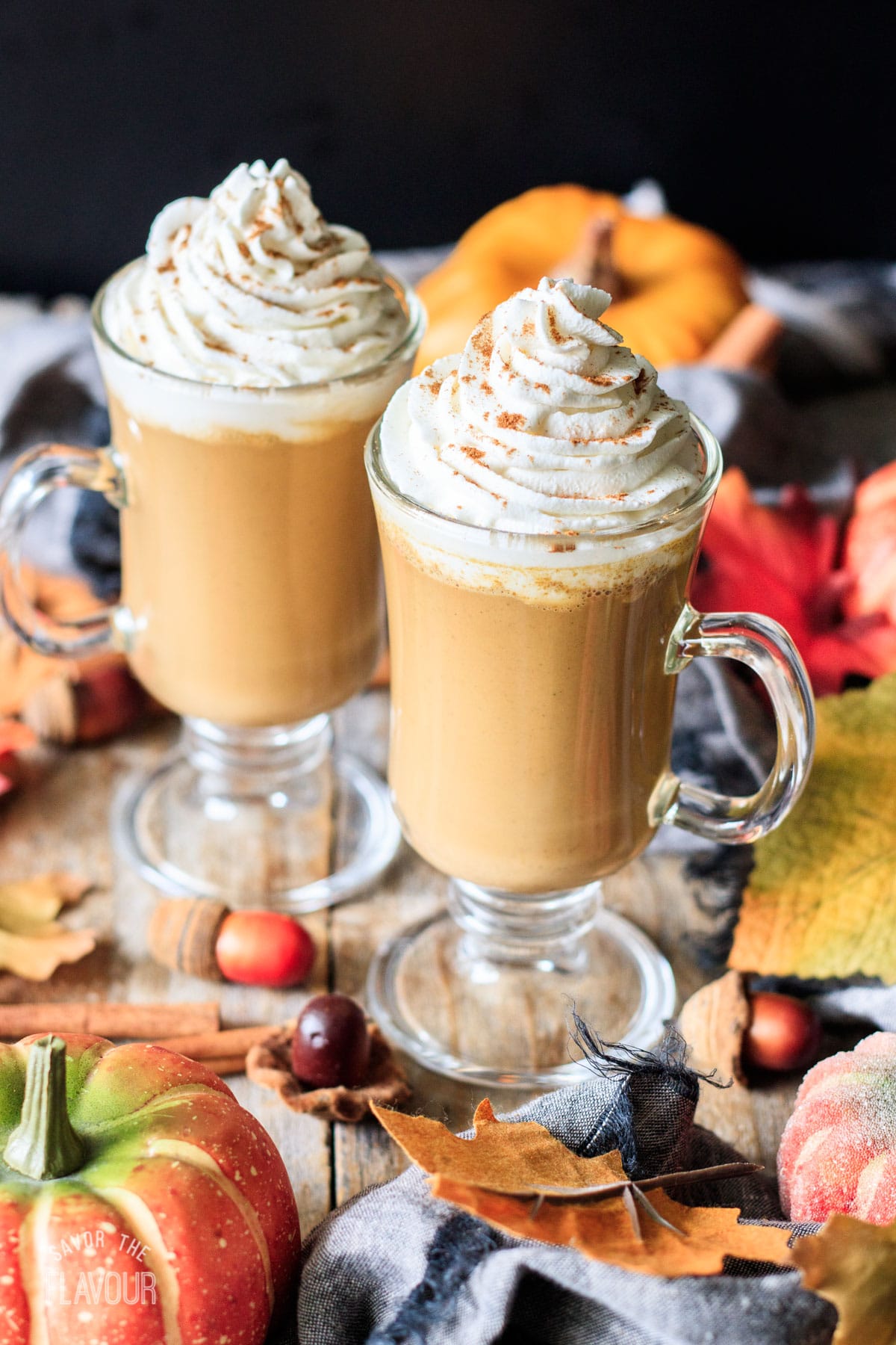 two pumpkin spice lattes with whipped cream and spice