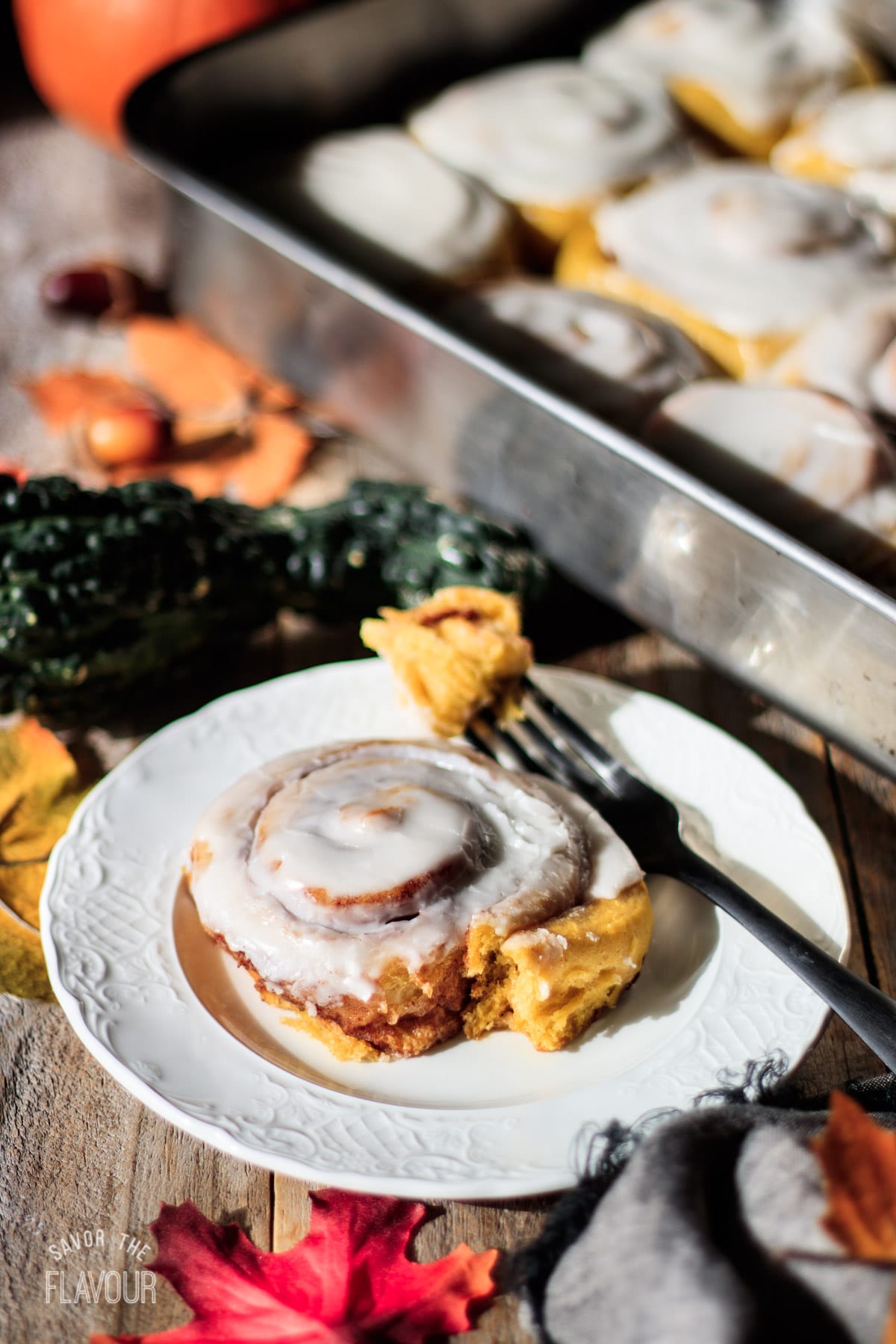 vegan pumpkin cinnamon roll on a white plate