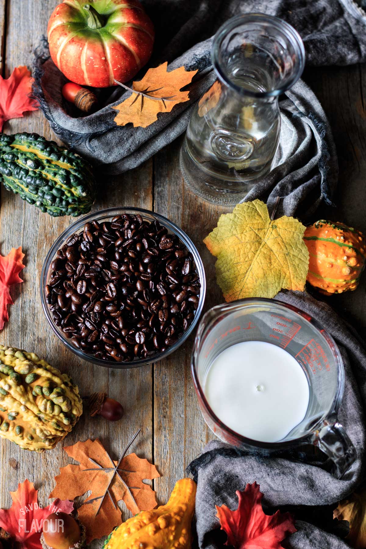 bowl of coffee beans and jugs of milk and water