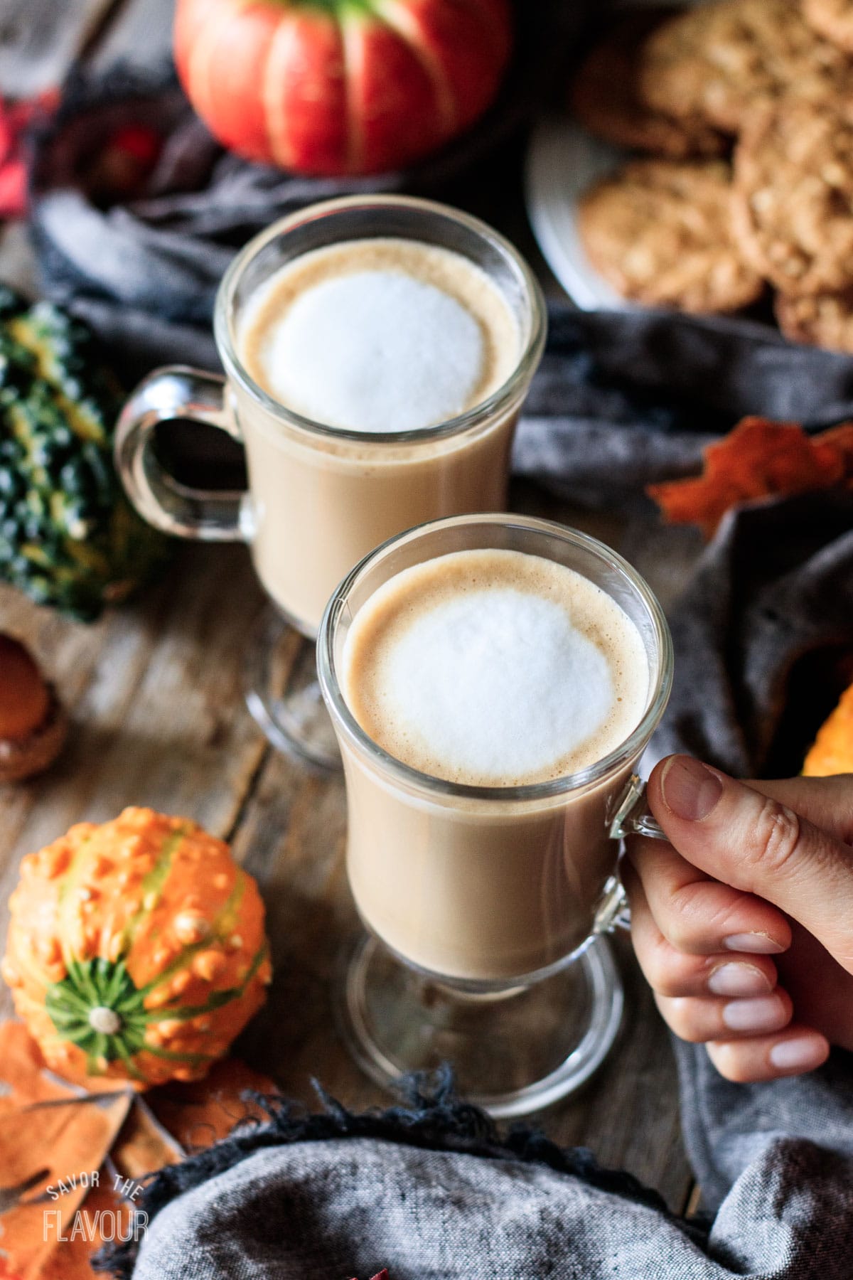 person holding a glass mug of flat white