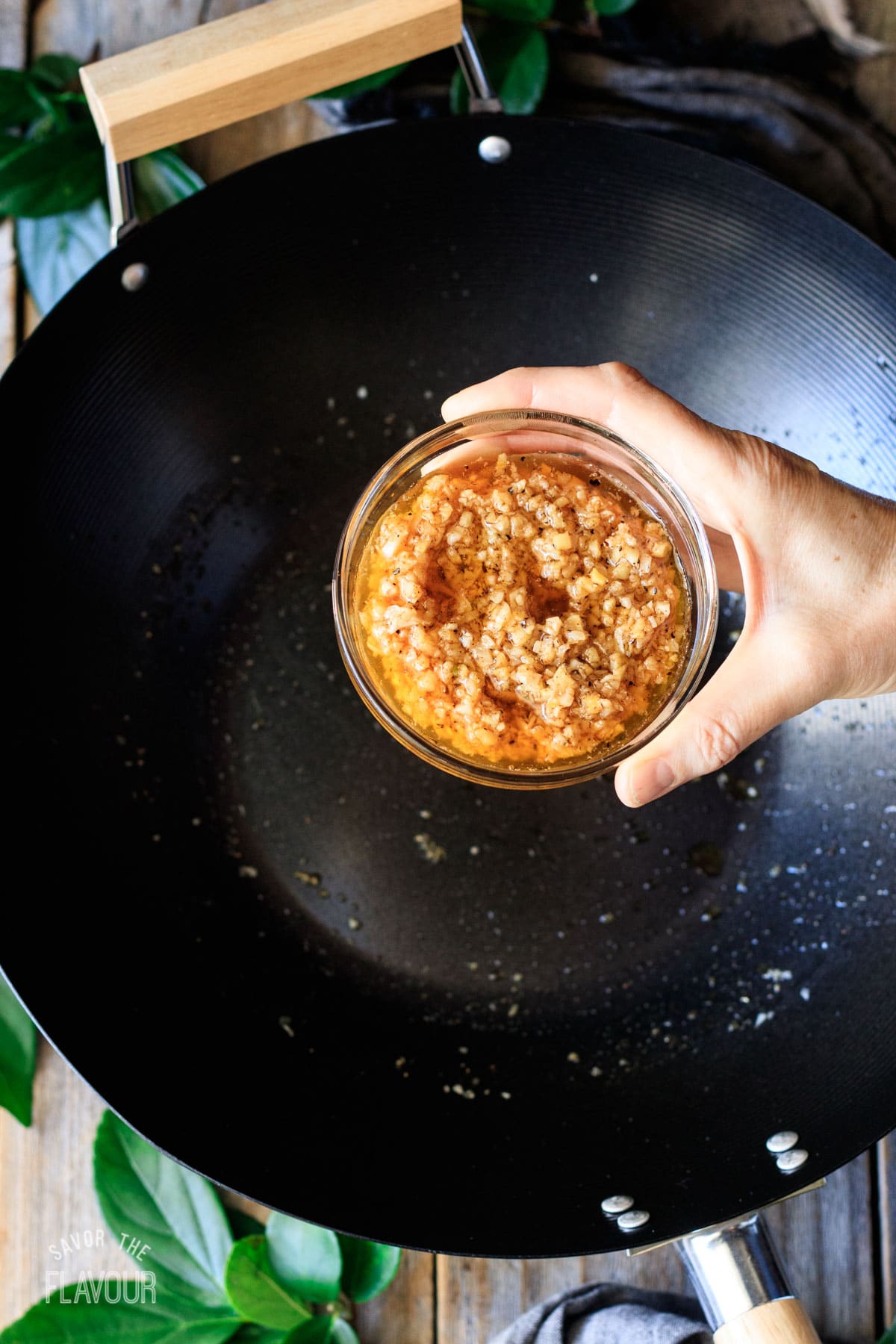 person holding a bowl of butter, spices, and sauteed ginger and garlic