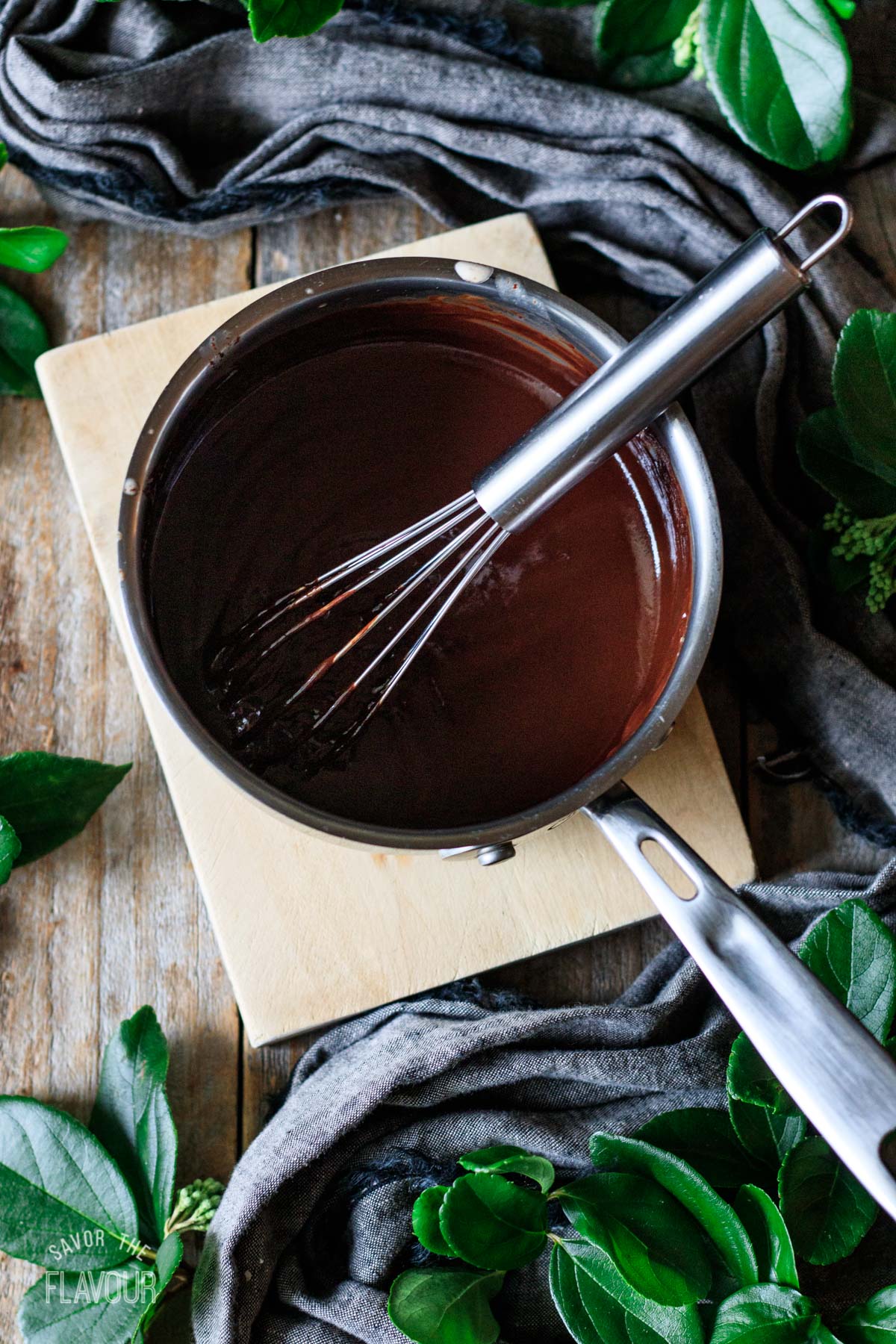 chocolate ganache in a small saucepan with a whisk