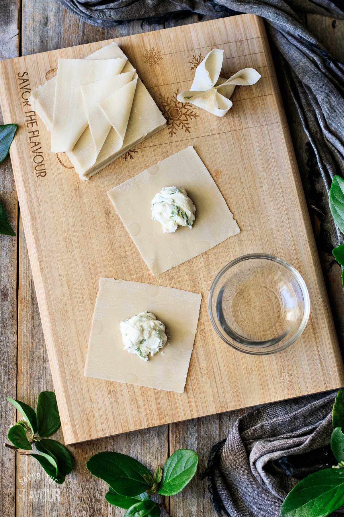 cream cheese filling and wontons on a cutting board