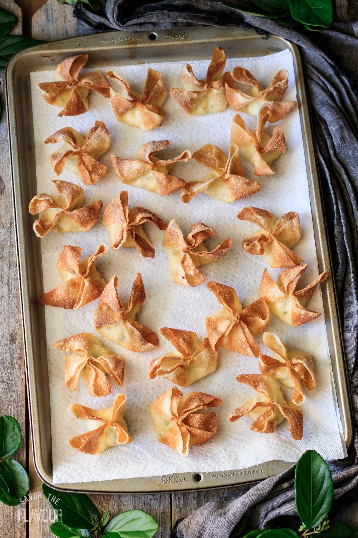 deep fried cream cheese rangoons draining on paper towels