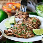 person holding a forkful of sliced carne asada