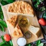 three slices of black pepper focaccia with the loaf